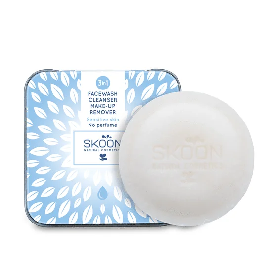 Pureday Et stykke hvid hudplejesæbe ved siden af en åben blå dåse med hvidt bladmønster, mærket "skoon natural cosmetics, Facewash, Cleanser og Makeup Remover - Sensitiv for følsom hud, nej Pureday Et stykke hvid hudplejesæbe ved siden af en åben blå dåse med hvidt bladmønster, mærket "skoon natural cosmetics, Facewash, Cleanser og Makeup Remover - Sensitiv for følsom hud, nej